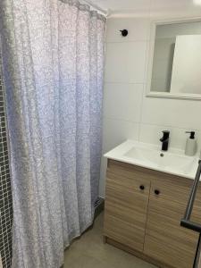 y baño con cortina de ducha y lavamanos. en Casa mediterránea Villamar Guanaqueros en Guanaqueros