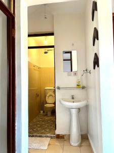 a bathroom with a sink and a toilet at Comfy 1br Milimani in Kisumu