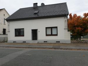 une maison blanche avec un toit noir dans une rue dans l'établissement Ferienwohnung Alstaden, à Oberhausen