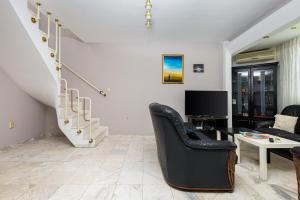 uma sala de estar com cadeiras pretas e uma mesa e escadas em Spacious 2-Bedroom Maisonette in City Centre em Plovdiv