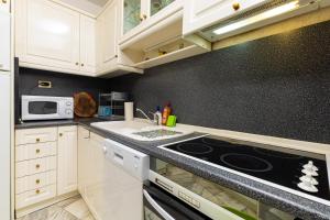 uma cozinha com armários brancos e um forno com placa de fogão em Spacious 2-Bedroom Maisonette in City Centre em Plovdiv