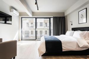 um quarto com uma cama grande e uma janela grande em WYZ Piraeus em Piraeus