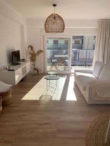 ein Wohnzimmer mit einem Sofa und einem Tisch in der Unterkunft Appartement boho chic près de la plage in Cambrils