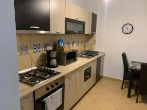 a kitchen with a stove top oven and a microwave at Confort Apartment in Mediaş