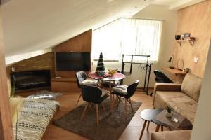 ein Wohnzimmer mit einem Tisch und einem Sofa in der Unterkunft Start Apartments LUX KOPAONIK in Kopaonik