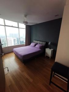 a bedroom with a purple bed and a large window at Vortex Suites KLCC by Fortune in Kuala Lumpur