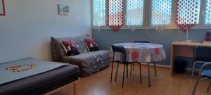 a room with a bed and a table and a couch at Studio proche CHU BORDEAUX in Bordeaux