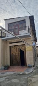 a house with a large wooden door and a balcony at Hotel GOLDEN DEGREZ in Bukhara