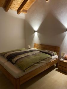 ein Schlafzimmer mit einem großen Bett mit einem Holzrahmen in der Unterkunft Dachgeschosswohnung mit traumhaftem Zugspitzblick bei Garmisch in Farchant