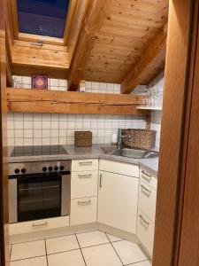 een keuken met een fornuis en een wastafel bij Dachgeschosswohnung mit traumhaftem Zugspitzblick bei Garmisch in Farchant