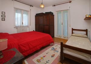 1 dormitorio con 1 cama roja y armario en Sauze Guesthouse Apartment, en Sauze dʼOulx