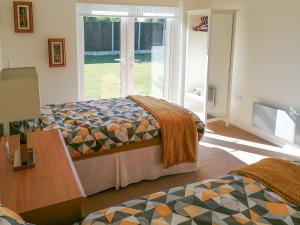 a bedroom with two beds and a table and a window at Acres View in Hoveringham