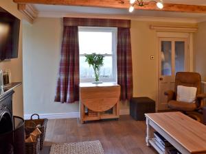 a living room with a window and a table at Coal Miners Cottage in New Mills