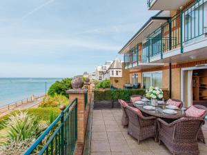 a patio with a table and chairs and the ocean at Solent View Apartment in West Cowes