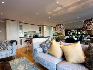 a living room with a couch and a kitchen at Solent View Apartment in West Cowes