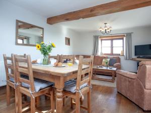 a dining room with a table and a couch at Smugglers Retreat in Hartland
