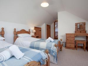 a bedroom with two beds and a mirror at Smugglers Retreat in Hartland