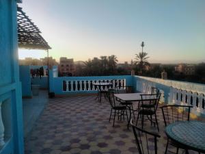 un patio avec tables et chaises sur un balcon dans l'établissement Maison d'Hôtes Ghalil, à Ouarzazate