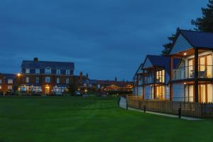 a large house with a lawn in front of it at Old Hunstanton Le Strange Arms Hotel in Hunstanton