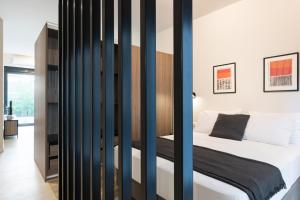 Schlafzimmer mit einem Bett mit schwarzen Trennwänden in der Unterkunft Voda Luxury Residence #102 in Athen