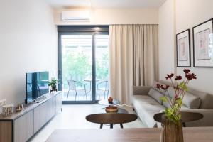 ein Wohnzimmer mit einem Sofa und einem TV in der Unterkunft Voda Luxury Residence #102 in Athen