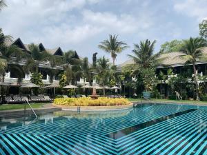 a swimming pool in front of a resort at Bensley Collection Pool Villas - Shinta Mani Angkor in Siem Reap