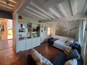 a living room with a bed and a couch at Chez le Petit Peintre in Laboissière-en-Thelle