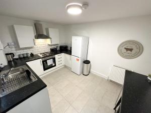a kitchen with a white refrigerator and white tile floors at Wenlock Liverpool in Liverpool