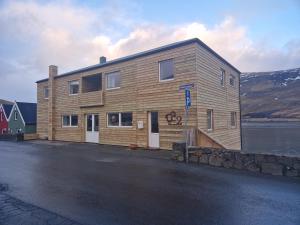 a wooden building on the side of a body of water at Guesthouse Hugo in Sørvágur