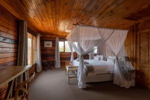 a bedroom with a canopy bed in a cabin at Palala River Cottages in Vaalwater