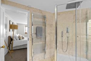 a bathroom with a shower and a bedroom with a bed at NEW 2023 Modern Luxury Holiday Home on the Beach in Devon - Free Parking, Pets Welcome, Sleeps 10 in Plymouth