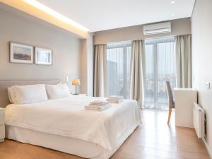1 dormitorio con cama blanca y ventana grande en Central Athens Loft en Athens