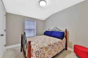 a bedroom with a bed and a red chair at Spacious renovated 4br downtown home w firepit sleeps 8+ in Saint Augustine