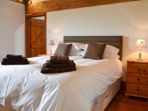 a bedroom with a large white bed with brown pillows at The Granary in Hornsea