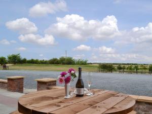 a bottle of wine and flowers on a wooden table at The Granary in Hornsea