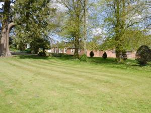 um grande campo de relva com um edifício ao fundo em Binbrook House Mews em binbrook