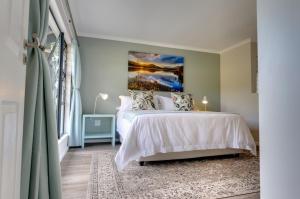 a bedroom with a bed and a painting on the wall at Giantscup Wilderness Reserve in Underberg