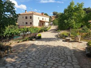 une passerelle en pierre menant à un bâtiment avec une maison dans l'établissement Casa Rural don Rosendo, à Olmeda de Cobeta