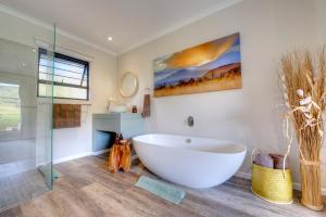 a bathroom with a large tub and a glass shower at Giantscup Wilderness Reserve in Underberg
