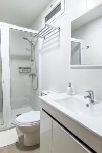 een witte badkamer met een toilet en een wastafel bij Estancia Victoria in La Orotava