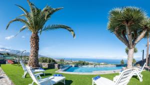 un complexe avec une piscine et des palmiers dans l'établissement Estancia Victoria, à La Orotava