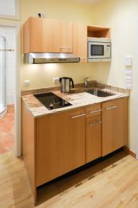 a kitchen with a sink and a microwave at Work & Travel - KRAL Hotels Erlangen in Erlangen