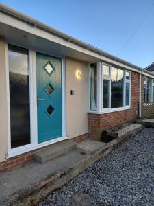 a front door of a house with a blue door at 2 double bedroom bungalow and free parking in Puriton