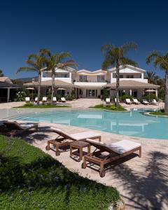 a swimming pool with two benches and a house at Sant Efis Hotel in Pula