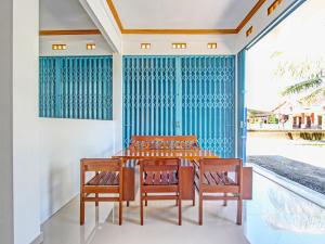 een eetkamer met een tafel en stoelen op een patio bij Super OYO 92101 Elma Guesthouse in Yogyakarta