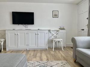 a living room with a white cabinet with a tv on it at 7 Alfred Square in Deal