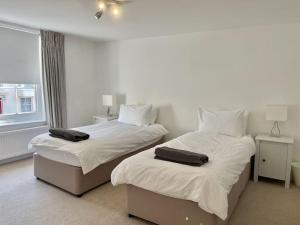 a bedroom with two beds with towels on them at 7 Alfred Square in Deal