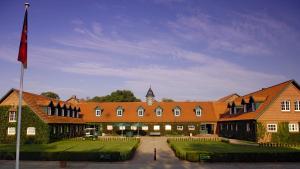 ein großes Gebäude mit einer Flagge davor in der Unterkunft Schloss Lüdersburg Golf & Spa in Lüdersburg