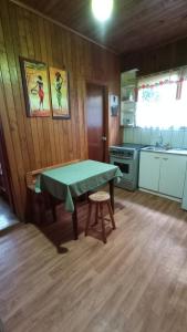 a kitchen with a green table in a room at Hostal Casa Damasco in Ancud