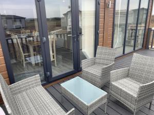 a patio with two chairs and a table on a balcony at Cedar 36 Hot Tub in Garton